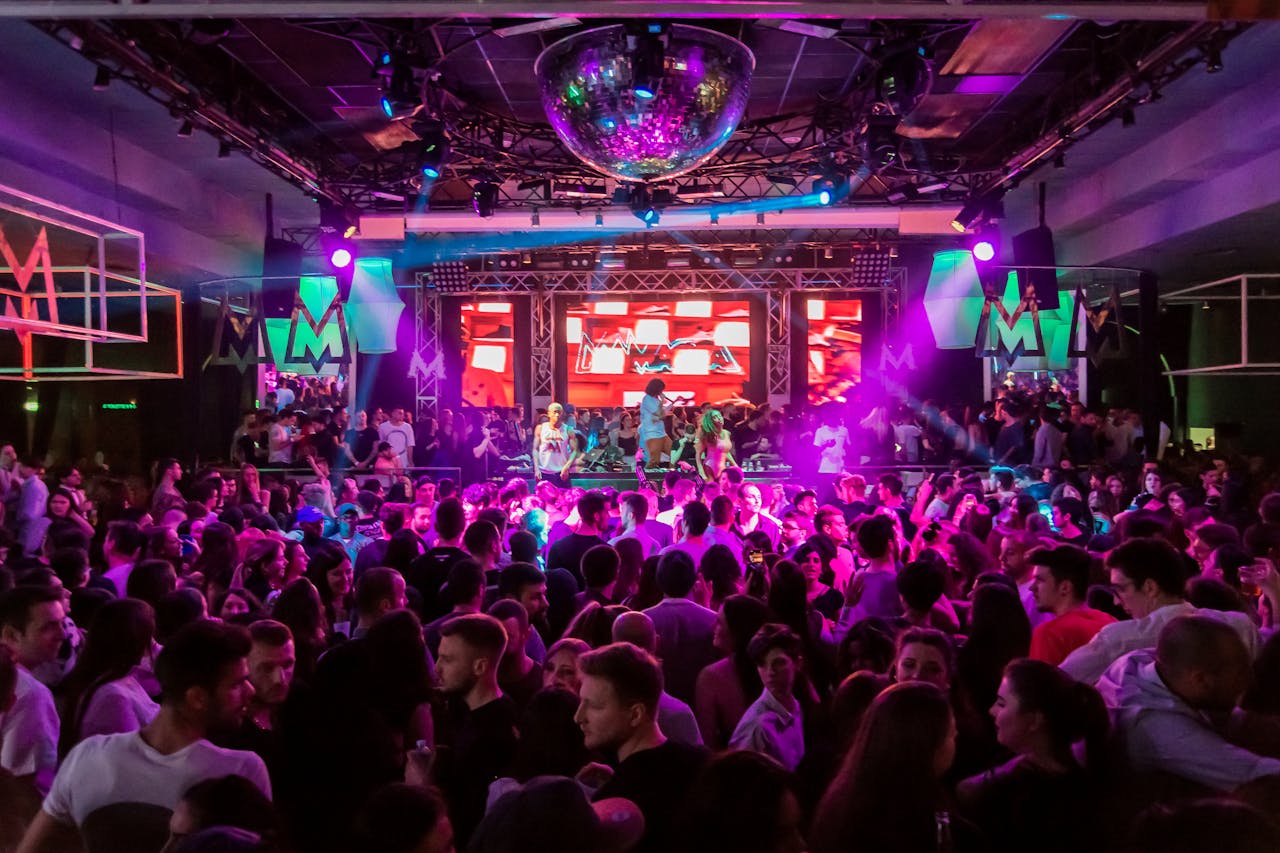 Services Dynamic crowd at a lively nightclub in Mantua, Italy, with vibrant lights and energetic atmosphere.