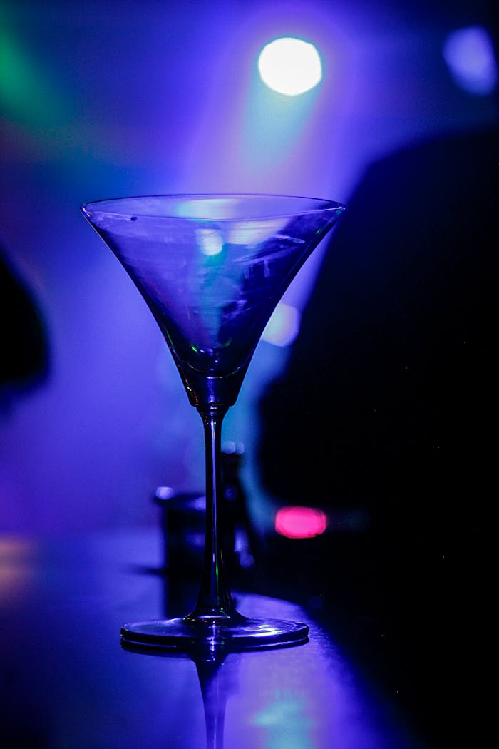 Services A crystal martini glass glows under vibrant nightclub lighting.